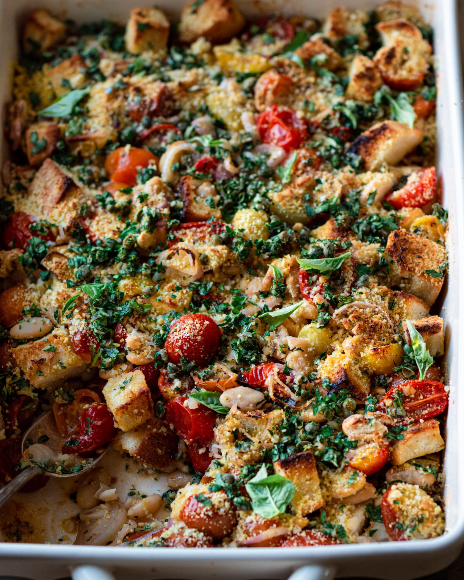 closeup tomato and white bean casserole with fresh herbs.