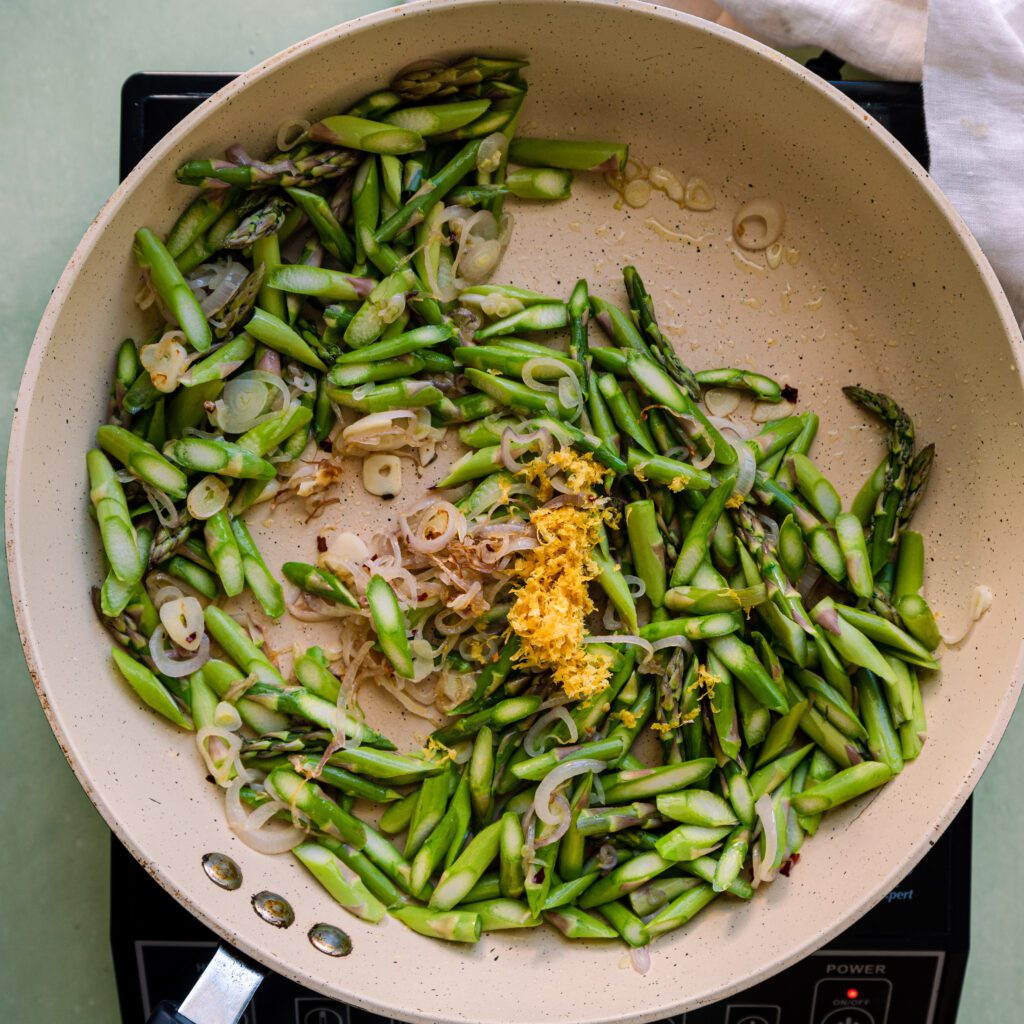 sauteing asparagus, lemon zest,and garlic in olive oil in frying pan