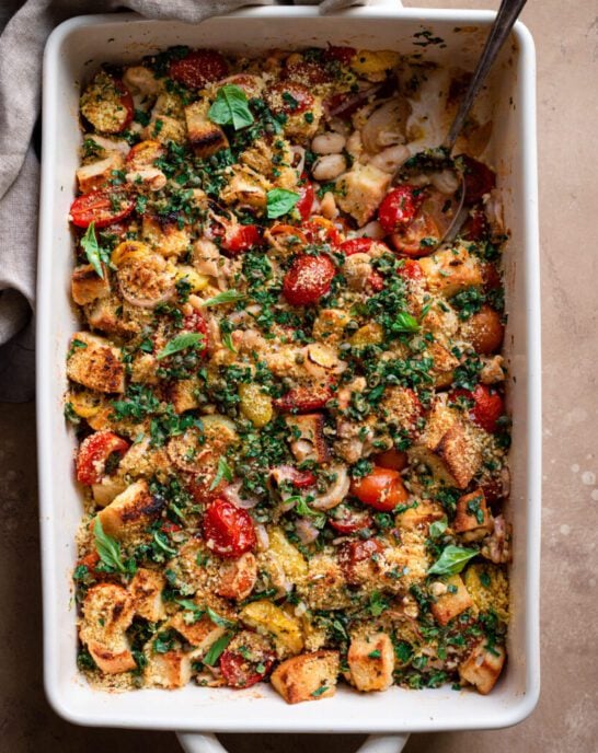 tomato white bean casserole in baking pan with gremolata on top.