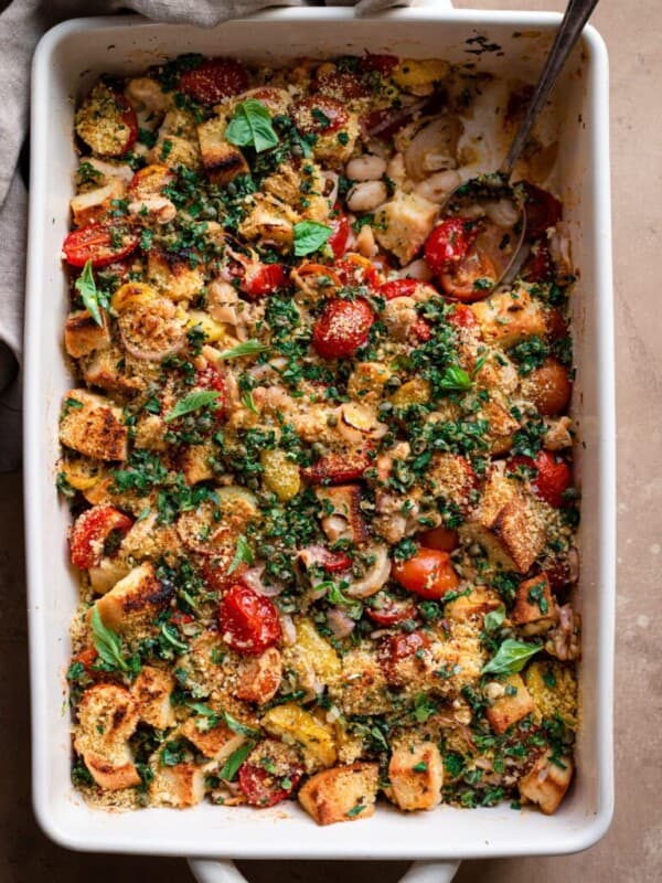 tomato white bean casserole in baking pan with gremolata on top.
