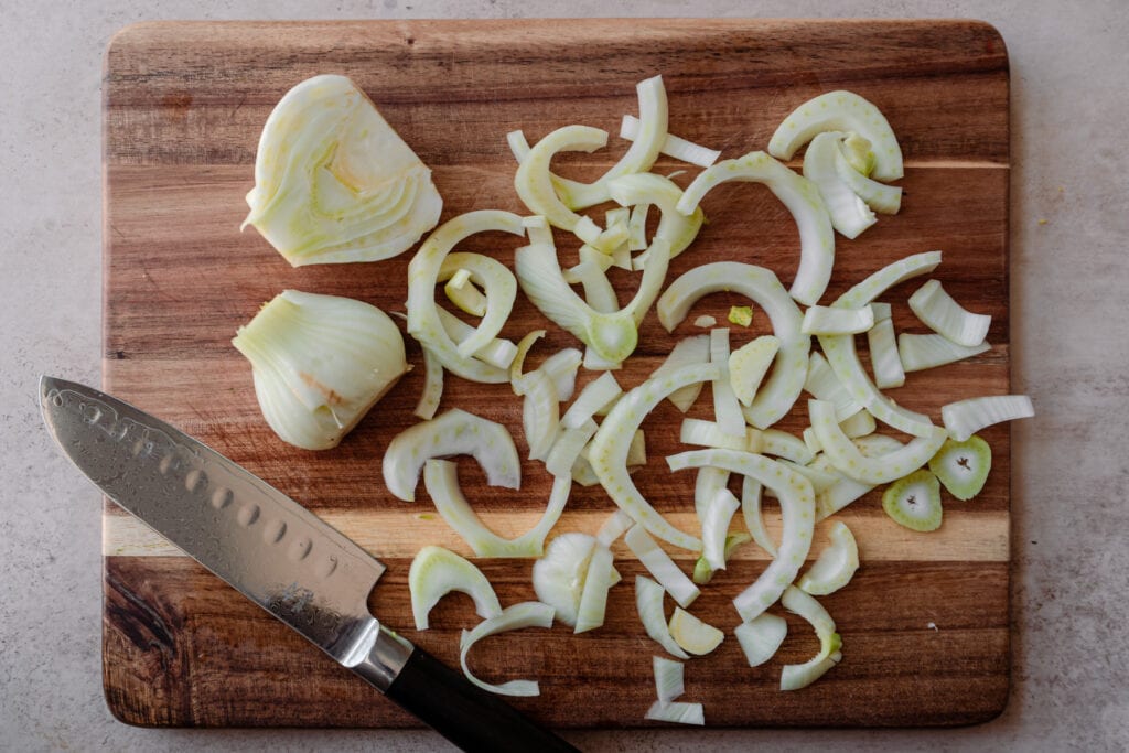 slicing fennel into rings on cutting board