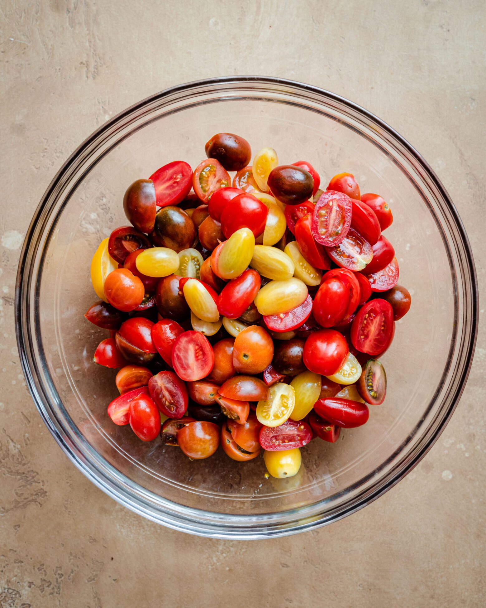 sliced cherry tomatoes in glass bowl.