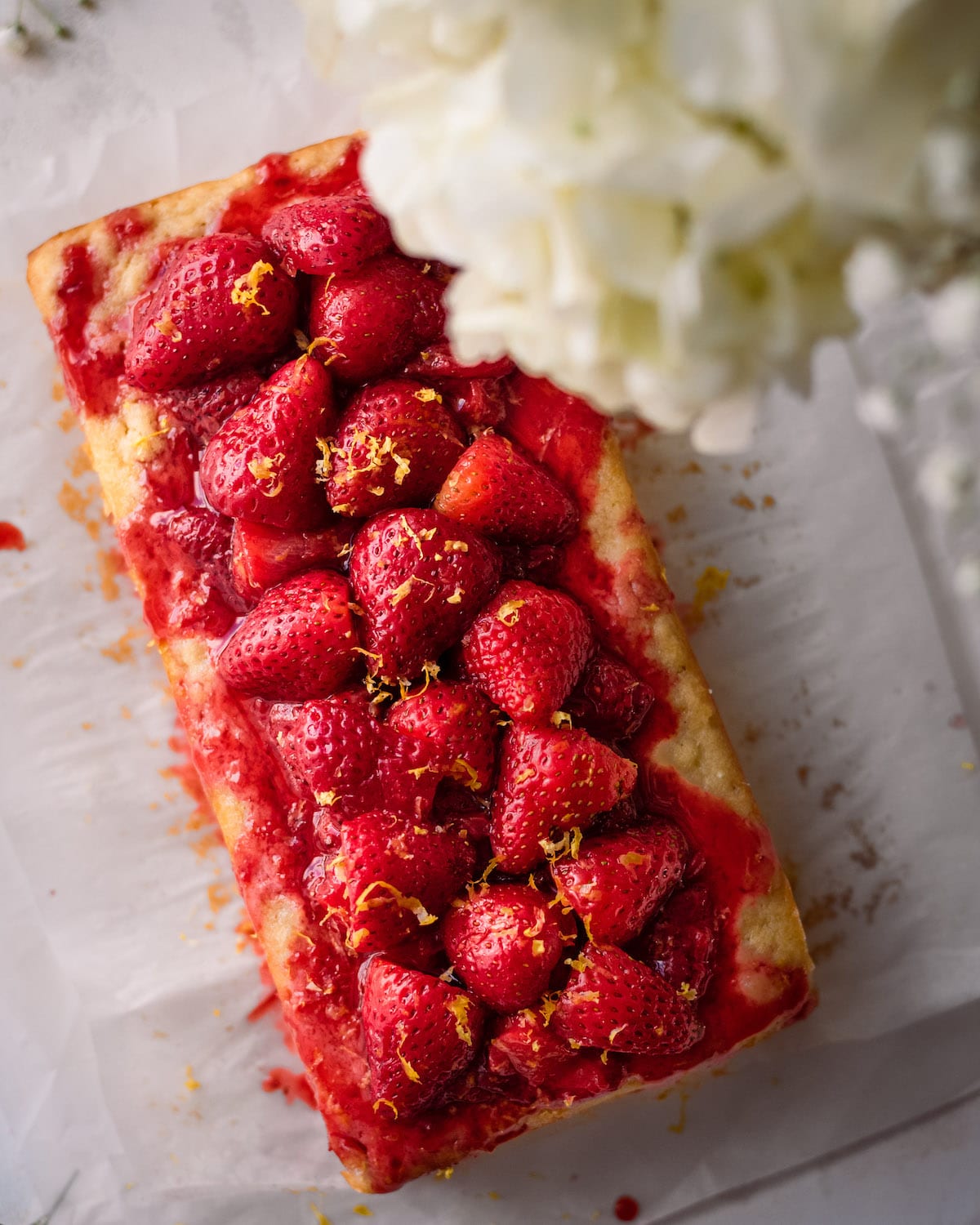 lemon strawberry cake on parchment paper with flowers