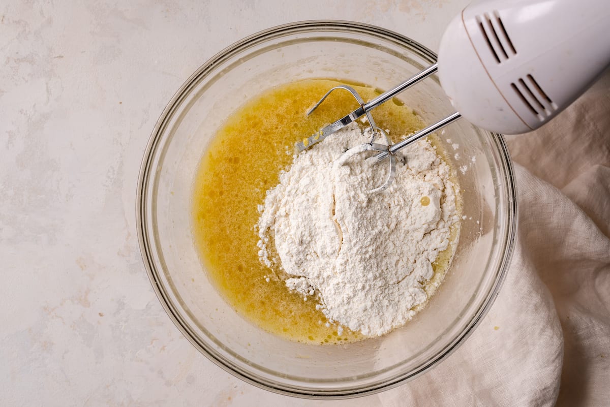 mixing flour into wet ingredients for lemon olive oil cake