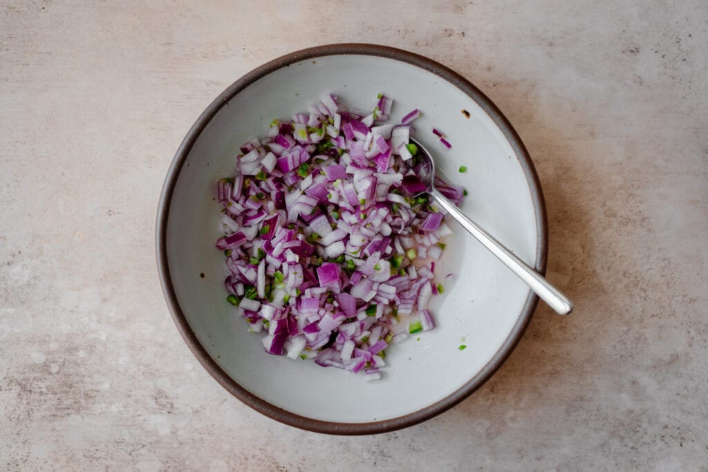 diced red onion and chili pepper in a bowl