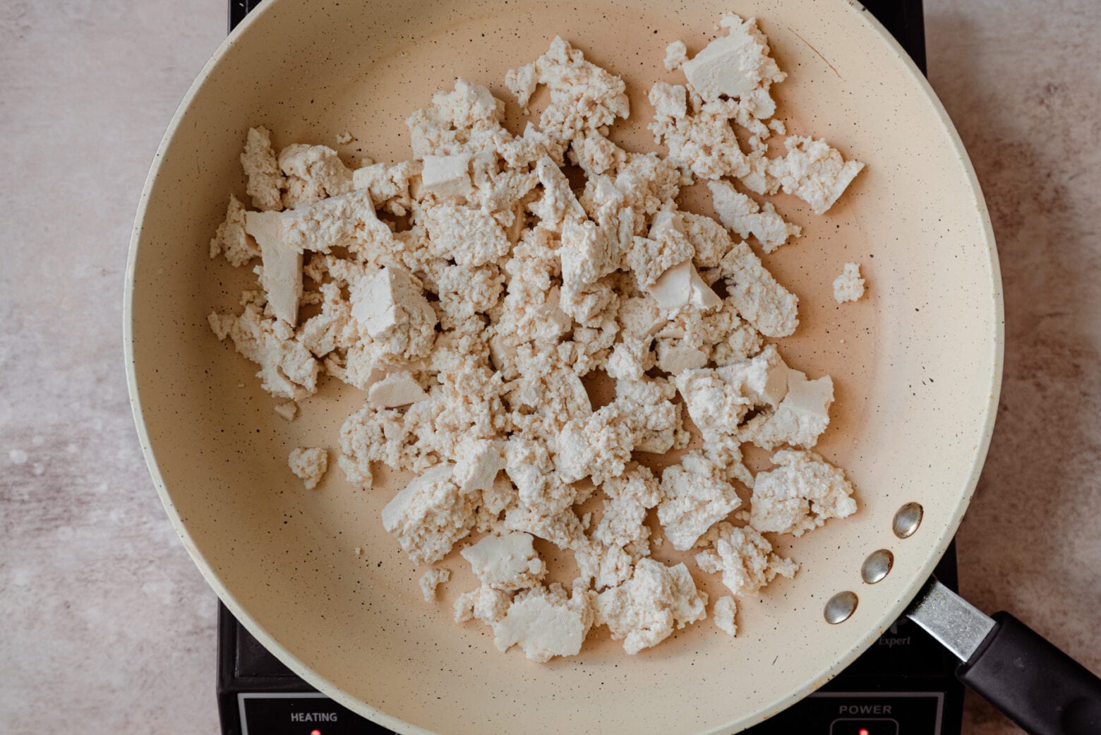 crumbled tofu in saute pan, about to make tofu scramble