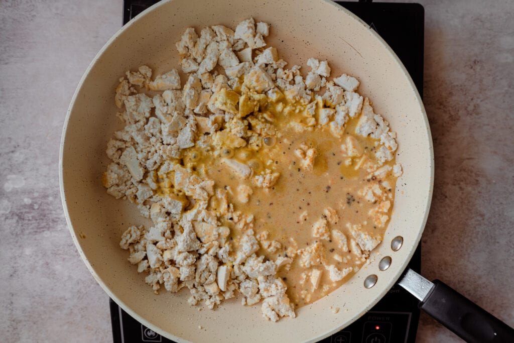 sauce added to fried tofu in skillet.