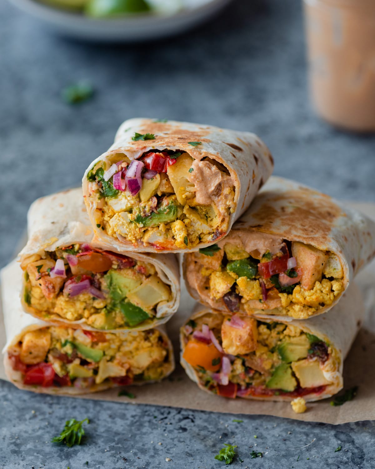  a stack of vegan breakfast burritos on a blue backdrop