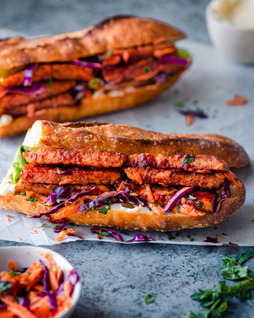 bbq glazed tempeh sandwich on parchment paper