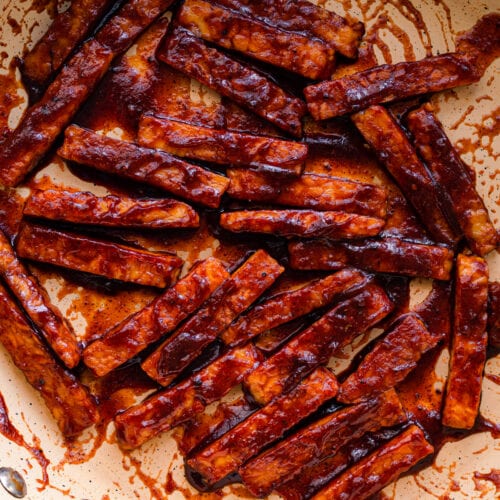 closeup photo of barbecue glazed tempeh in frying pan.