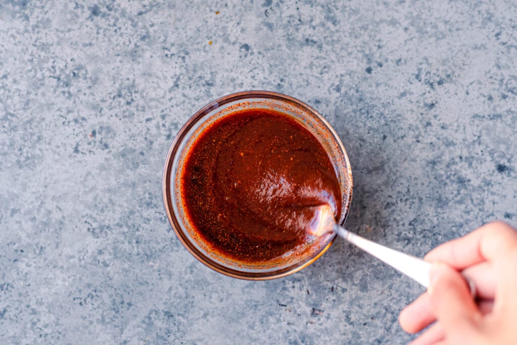 fork whisking homemade vegan barbecue sauce