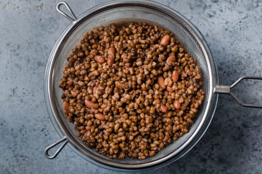 whole urad dal and kidney beans (rajma) in a colander