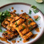 citrus-cilantro grilled tofu slabs on a white plate