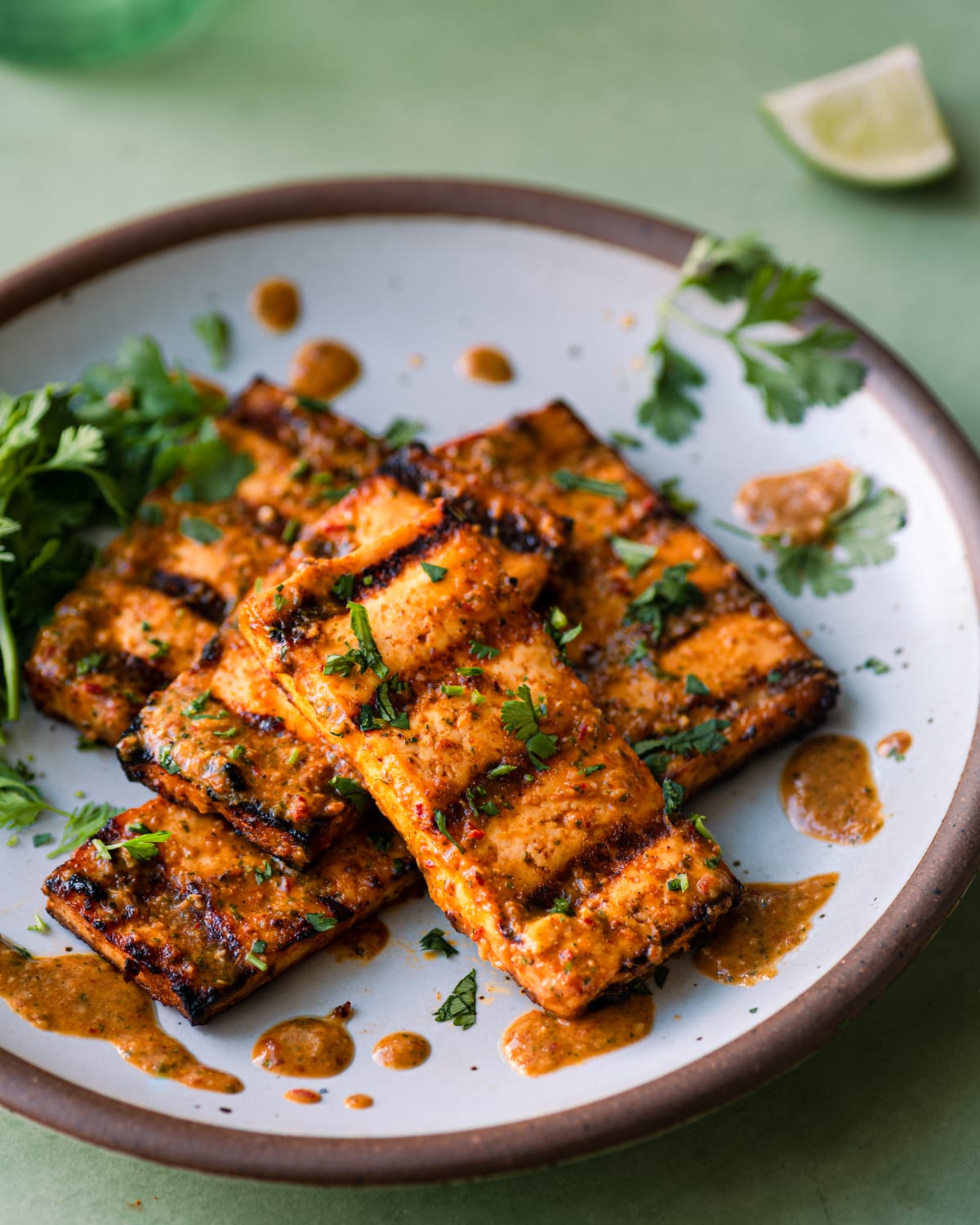 citrus-cilantro grilled tofu slabs on a white plate