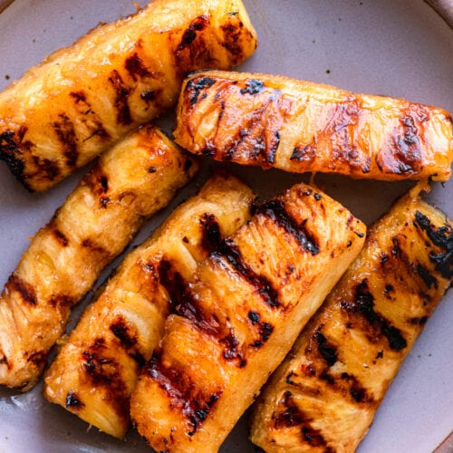 grilled pineapple spears on lavendar plate