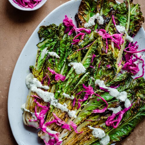 grilled romaine salad with creamy cashew dressing on pickled cabbage