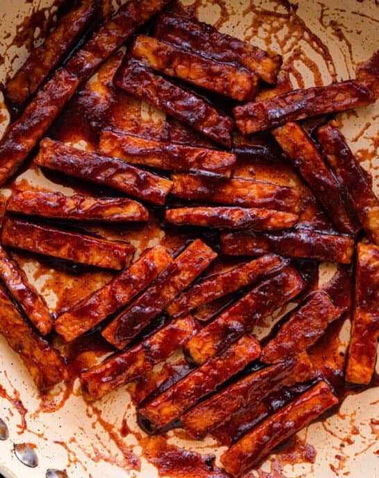 closeup photo of barbecue glazed tempeh in frying pan.