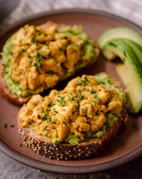vegan tofu scramble on top of avocado toast on plate