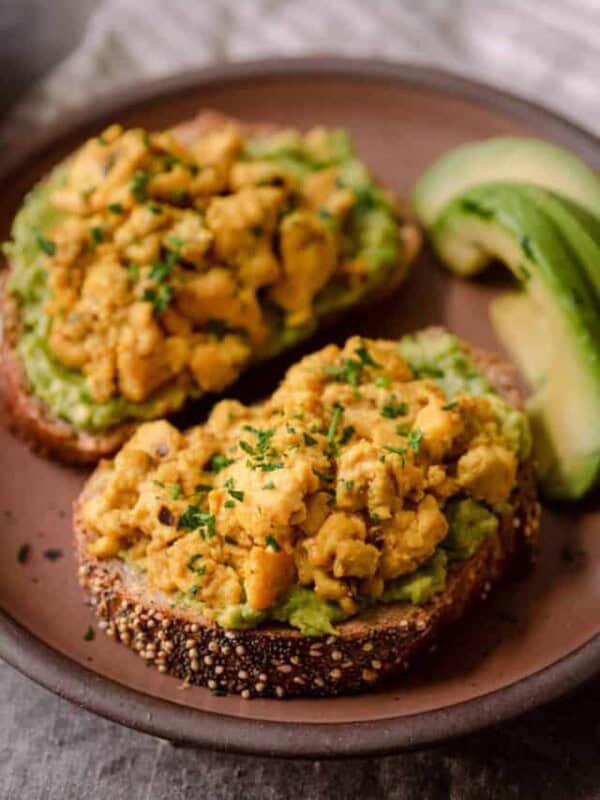 vegan tofu scramble on top of avocado toast on plate