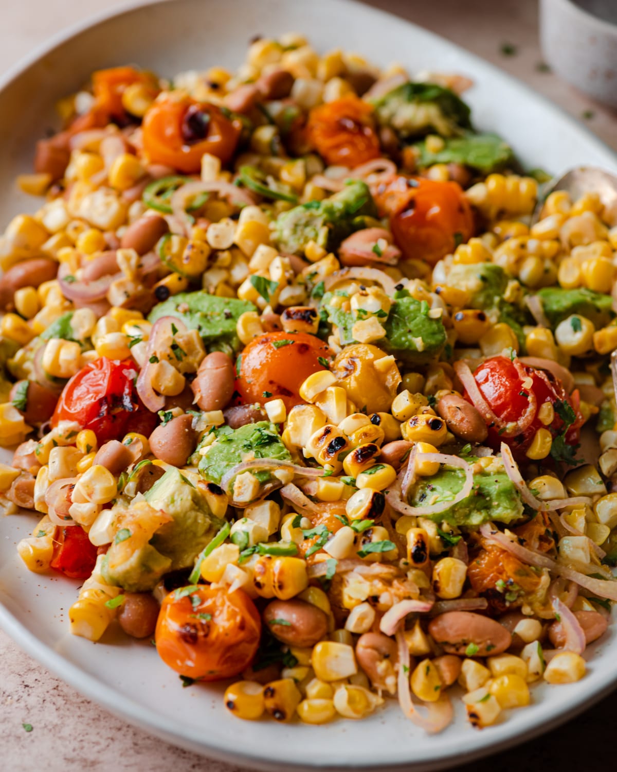 closeup photo of grilled corn salad on white platter