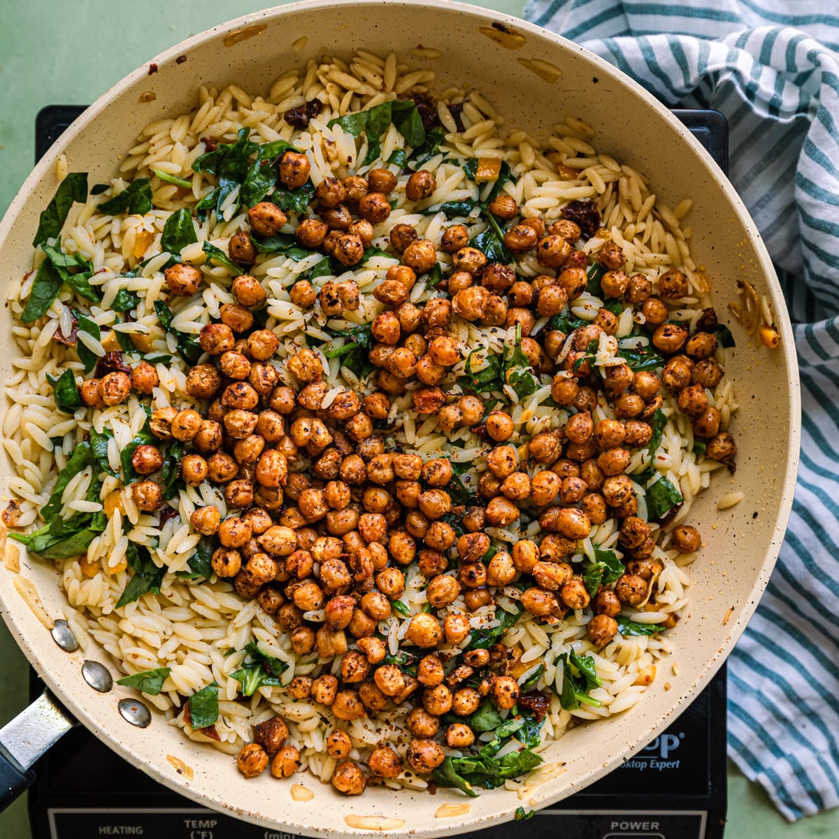 adding spiced chickpeas to orzo pasta salad