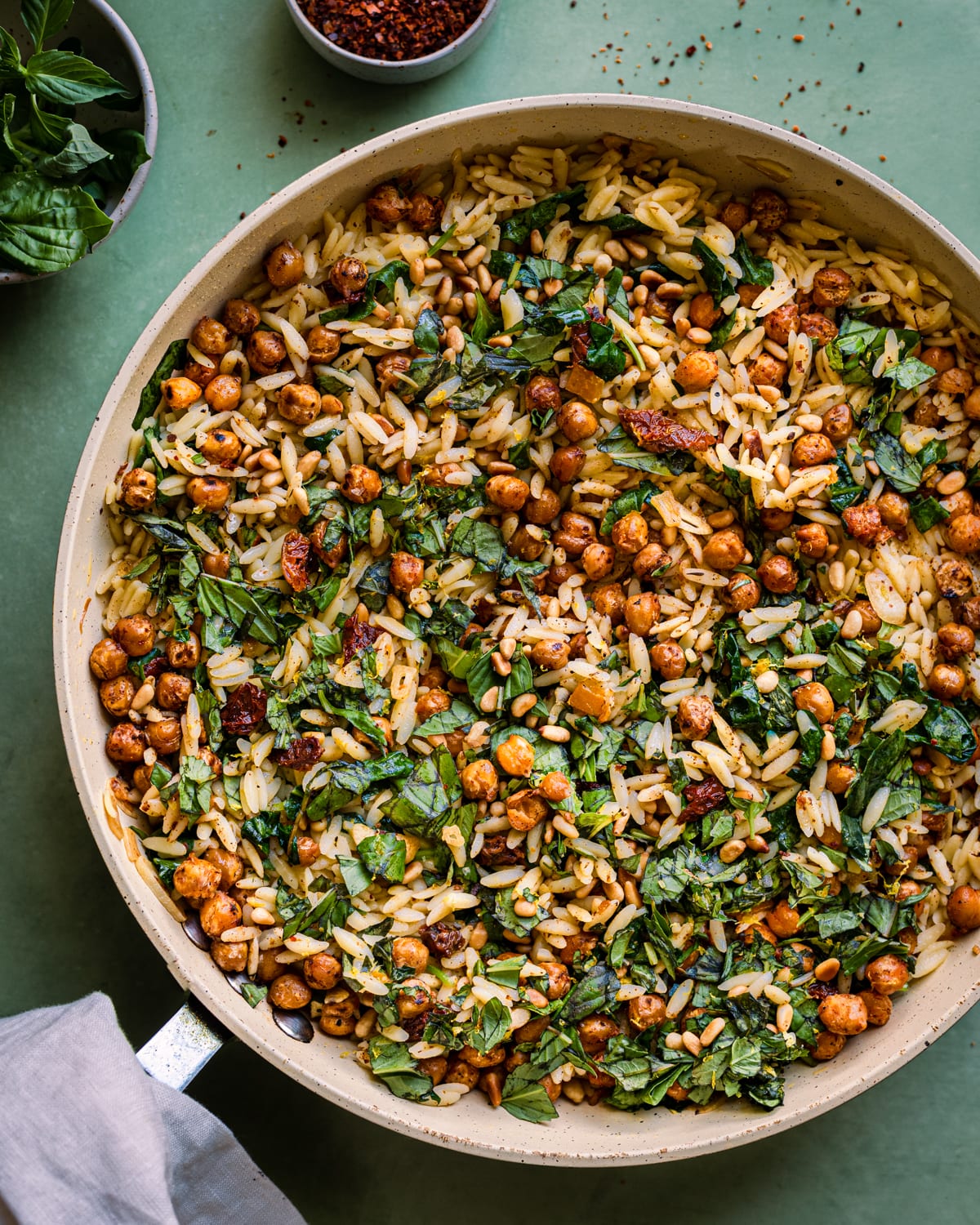 lemon orzo pasta salad with chickpeas in saute pan on green surface
