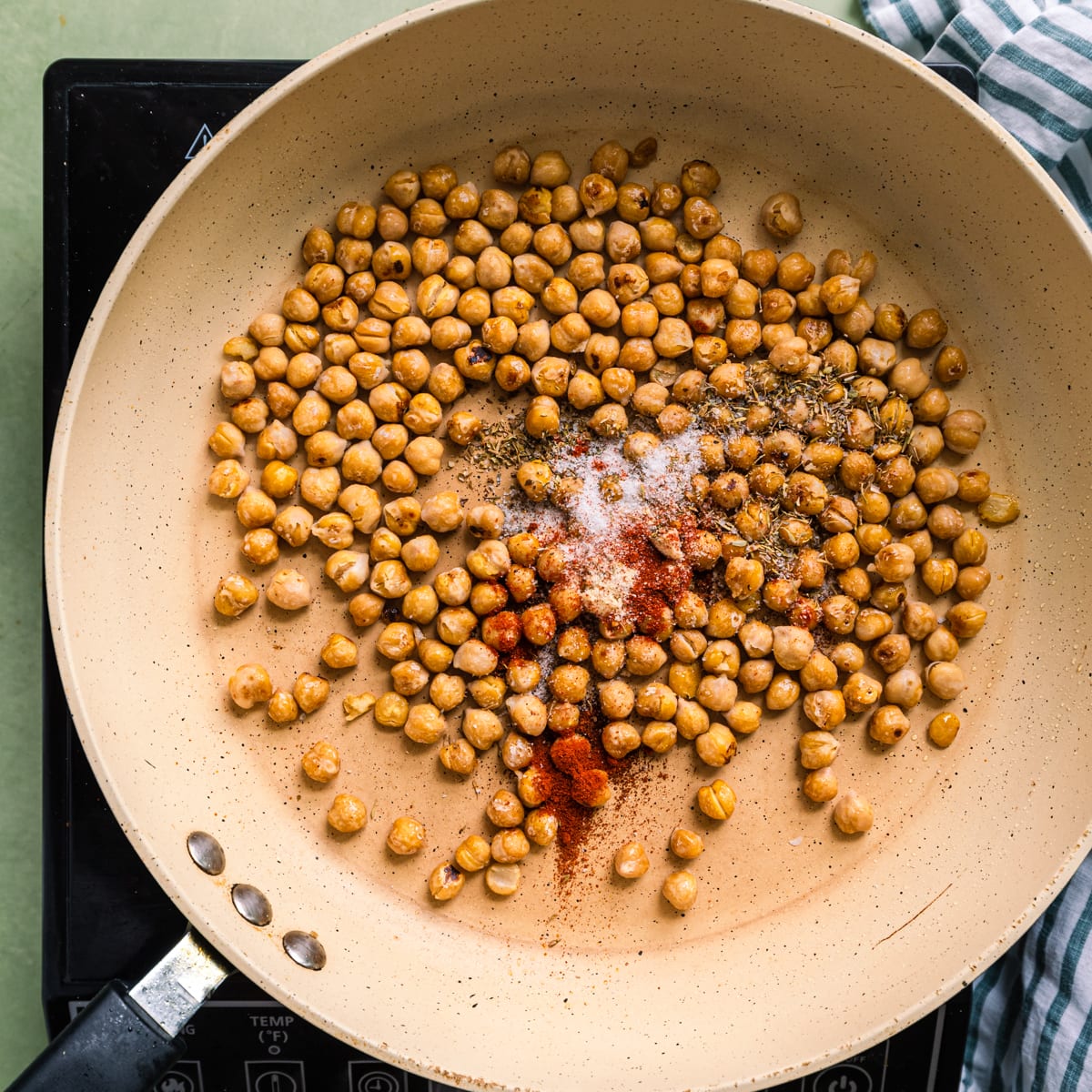 pan-frying chickpeas with spices in a saute pan