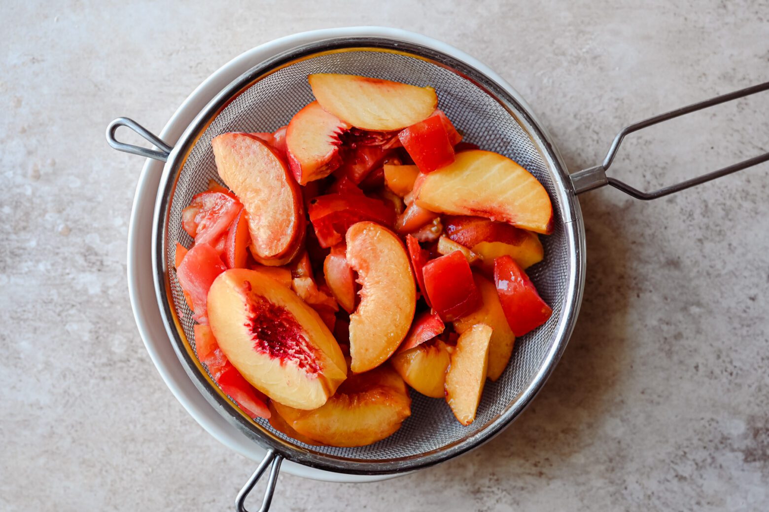 sliced peaches and tomatoes in colander