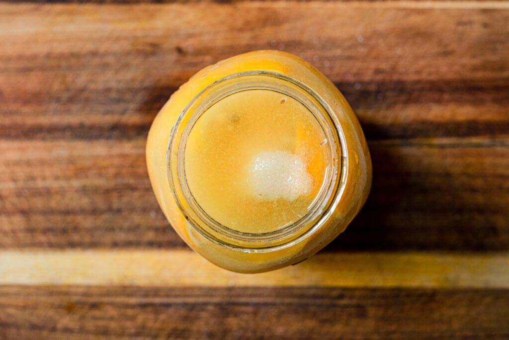 jar of preserved lemons with lemon juice on top 