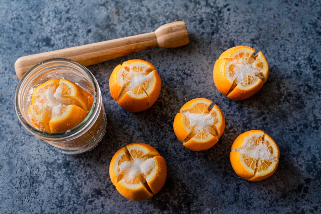 salted lemons for preserved lemons with a muddler and jar