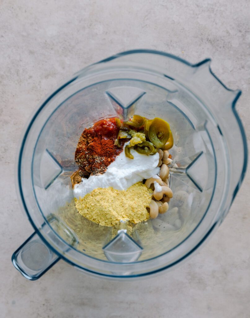 cashews, salsa, yogurt, spices, and nutritional yeast in a blender in blender