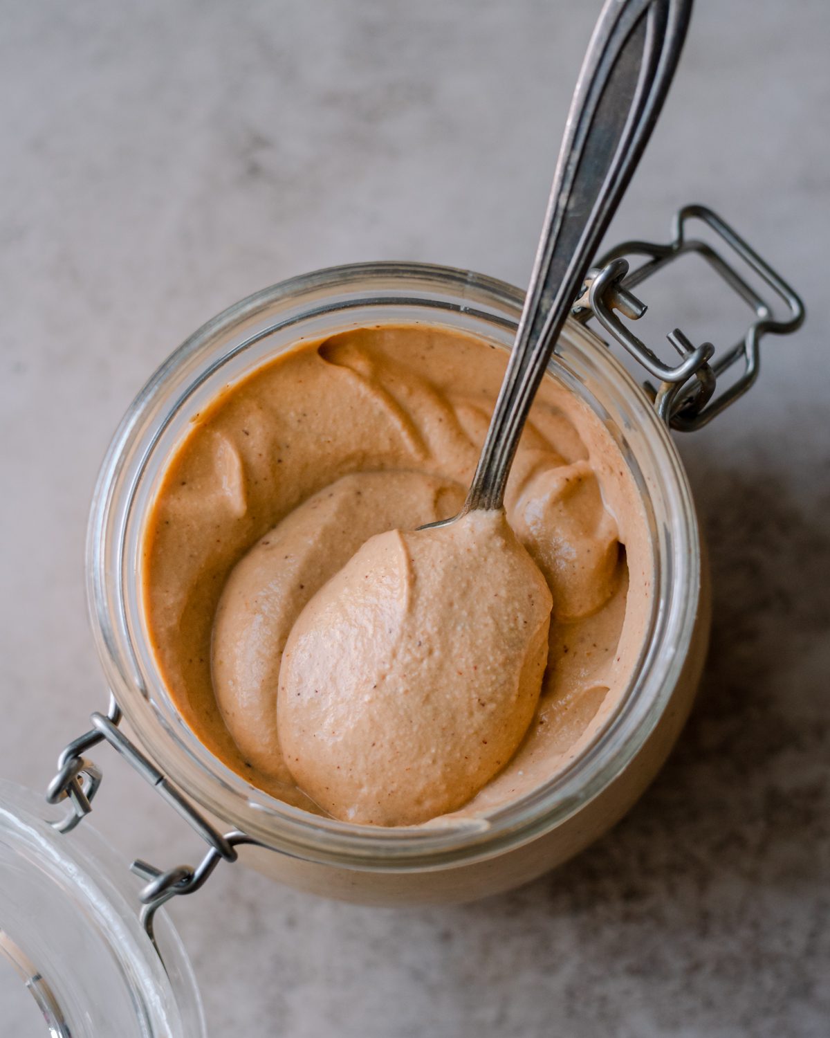 Spoon in a glass jar of queso.
