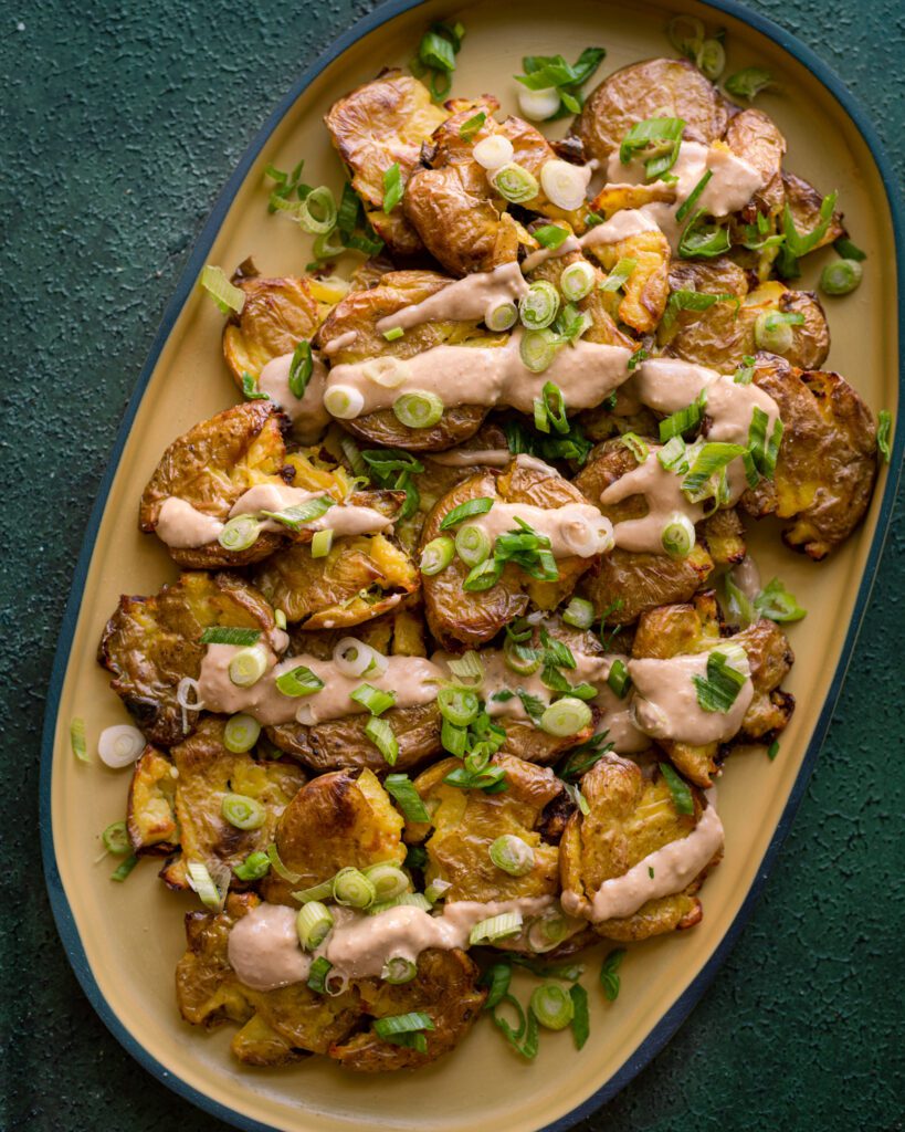 crispy smashed potatoes with ginger-tahini dressing and scallions