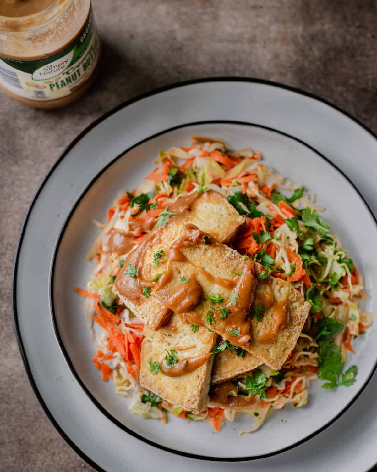 crispy tofu with peanut sauce over cabbage slaw