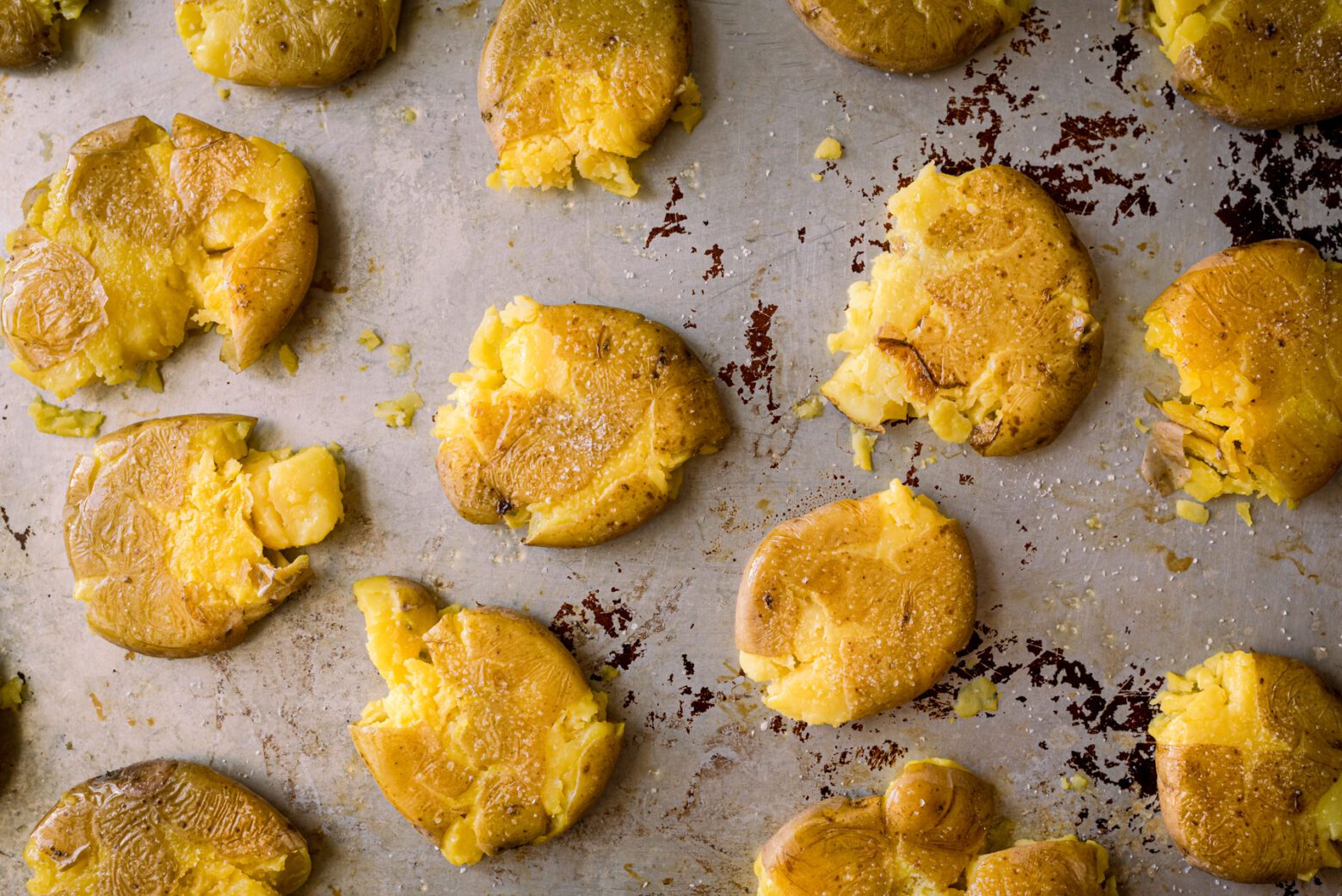 unbaked smashed potatoes on a baking sheet with oil and salt