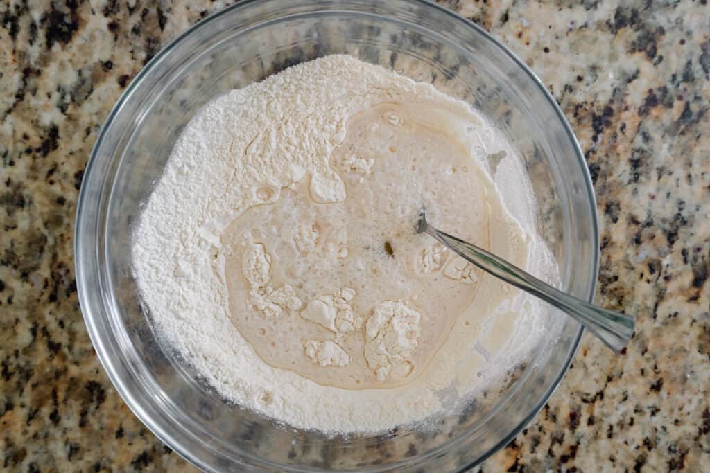 yeast, water and oil in a bowl of flour