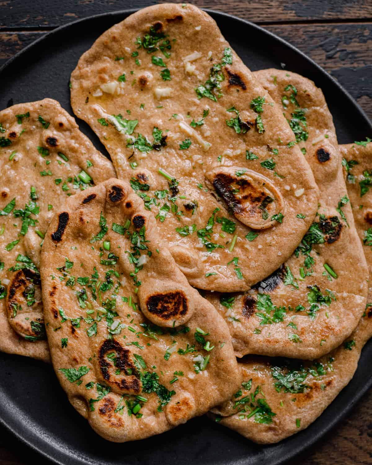 whole wheat vegan naan on a black plate