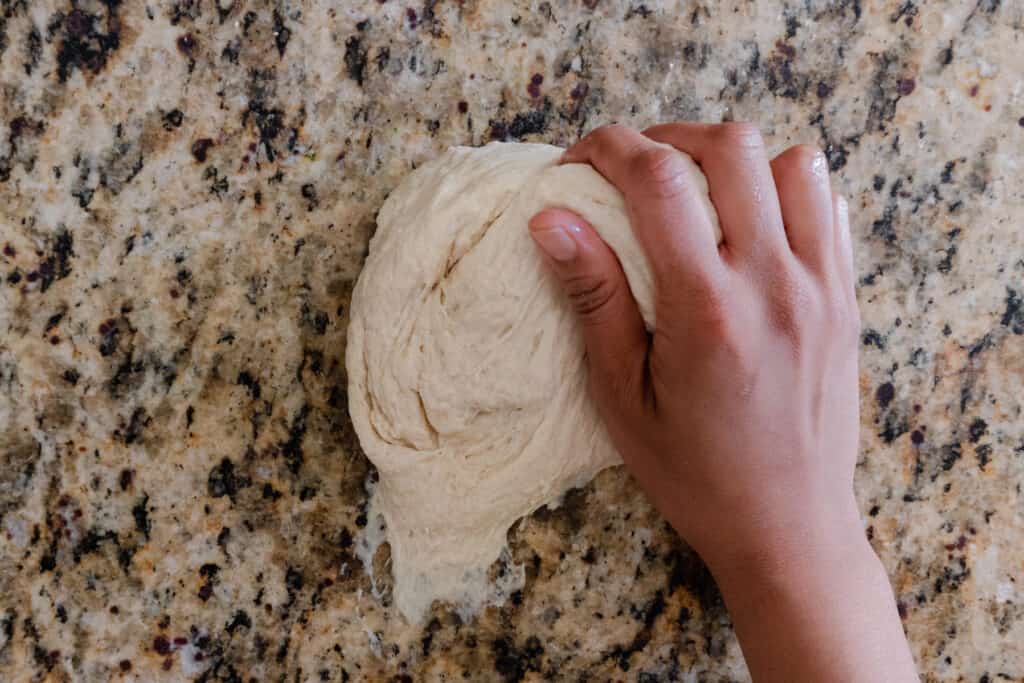 woman kneading sticky naan dough