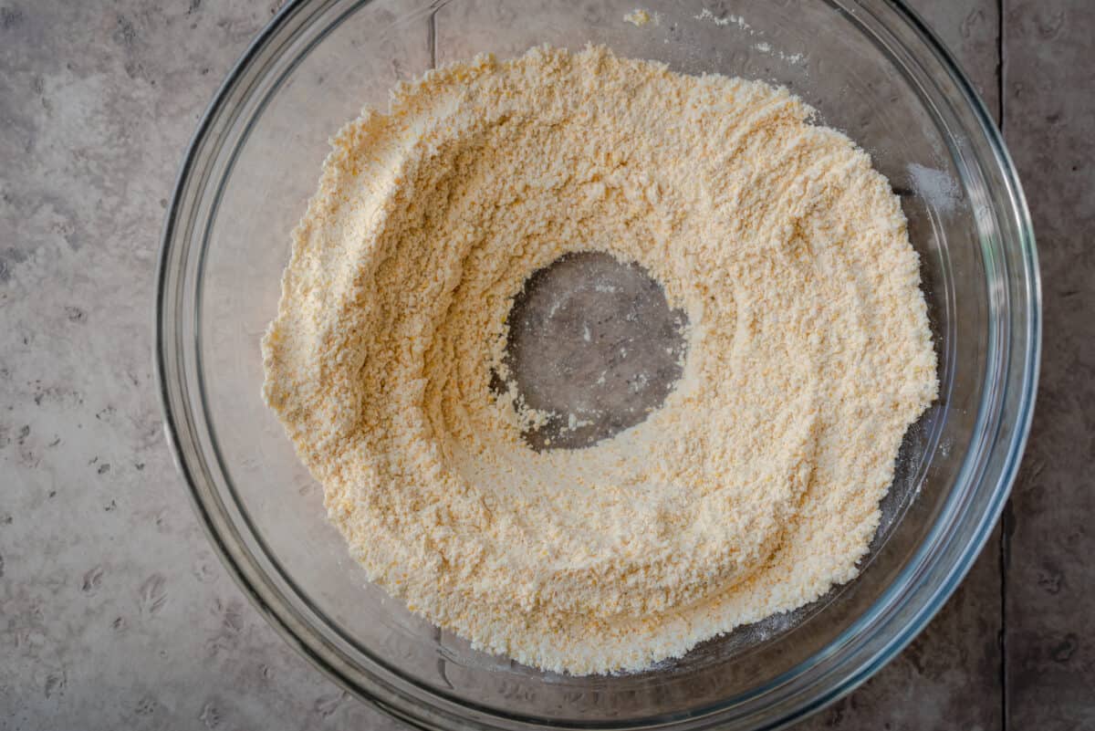 making a well in a bowl of cornmeal and flour