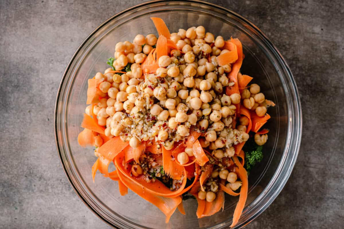 chickpeas on top of carrot ribbons in salad bowl