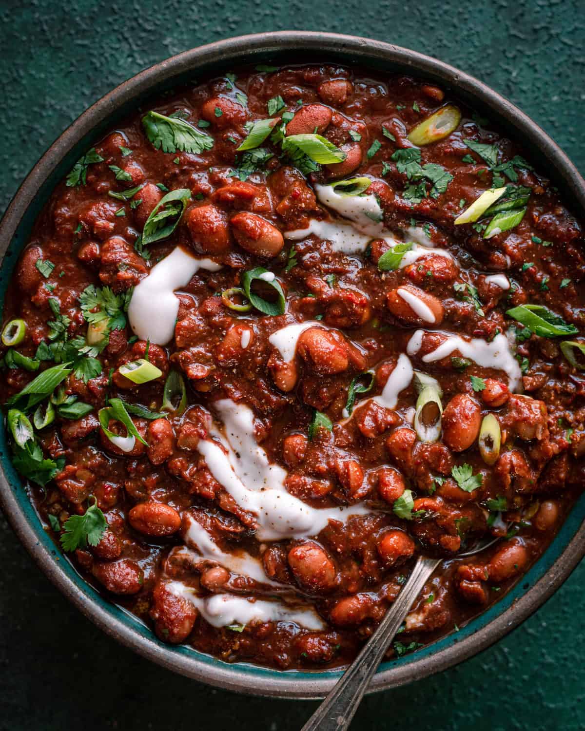 bowl of vegan chili with sour cream and cilantro