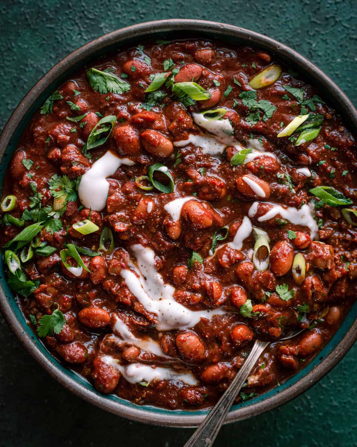 bowl of vegan chili with sour cream and cilantro.