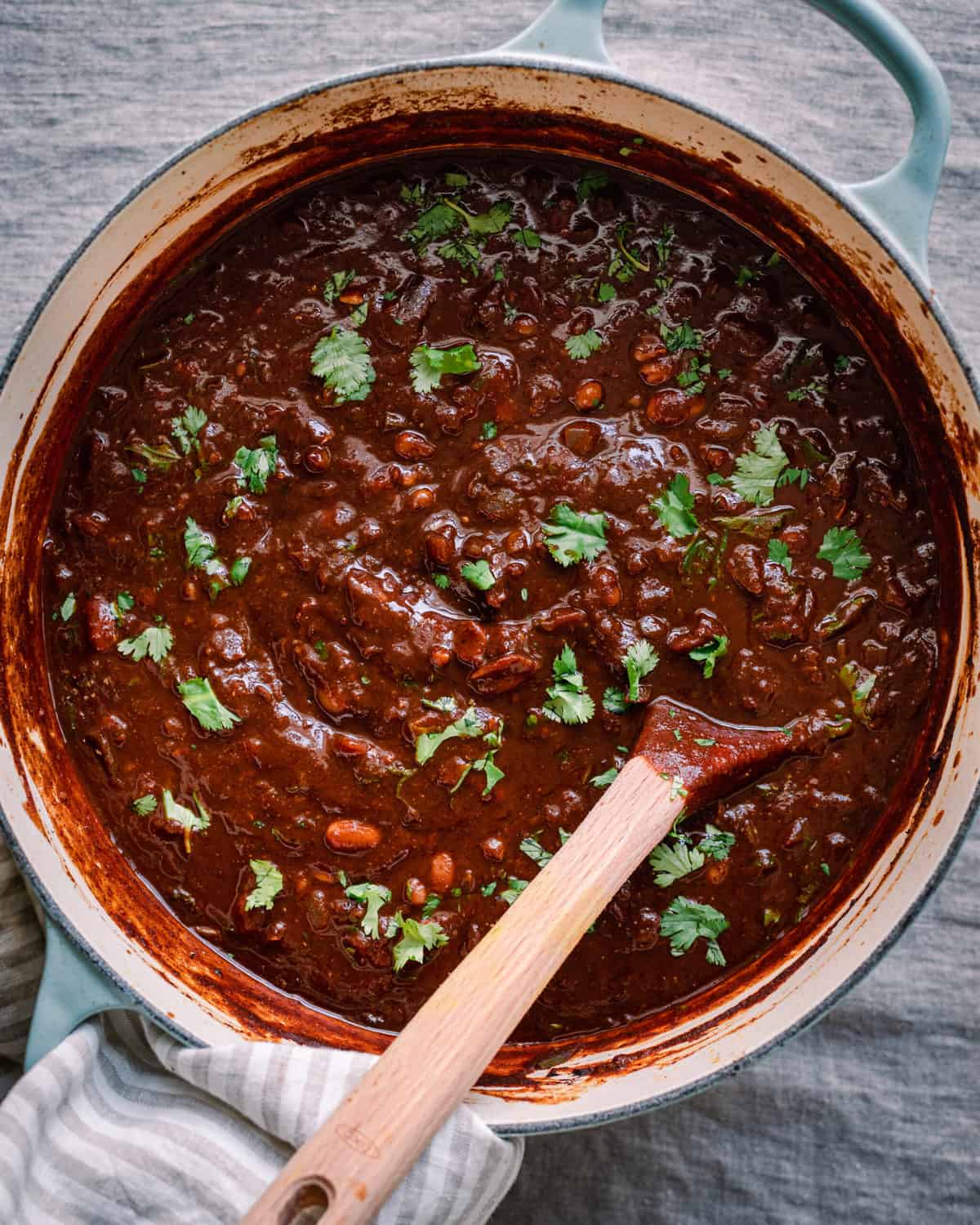 velvety, rich vegan chili in a dutch oven on linen tablecloth