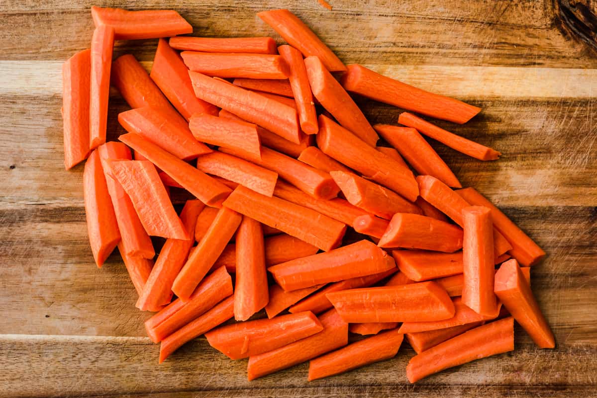Cut carrots on a wooden cutting board.