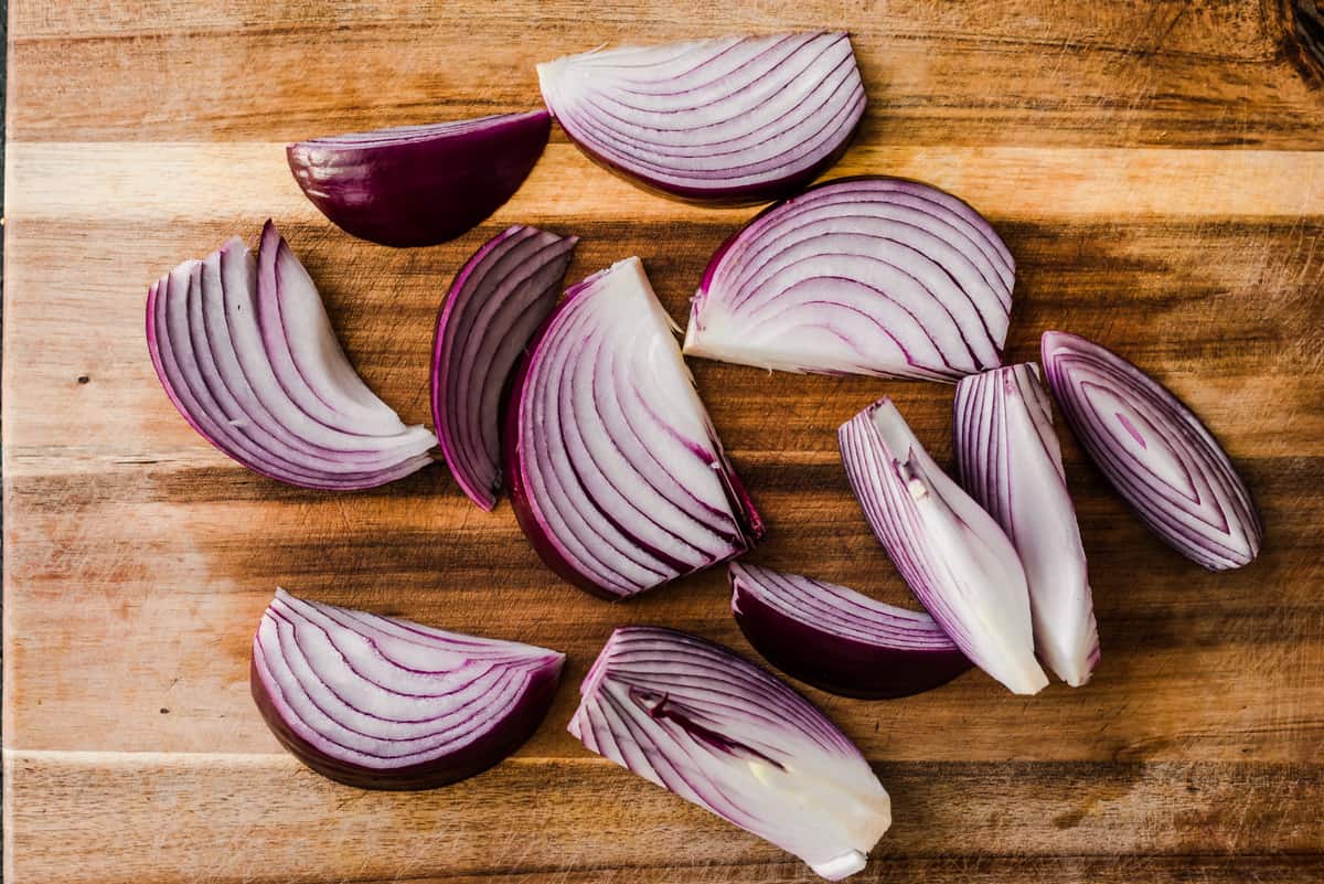 Cut onions on a wooden cutting board.