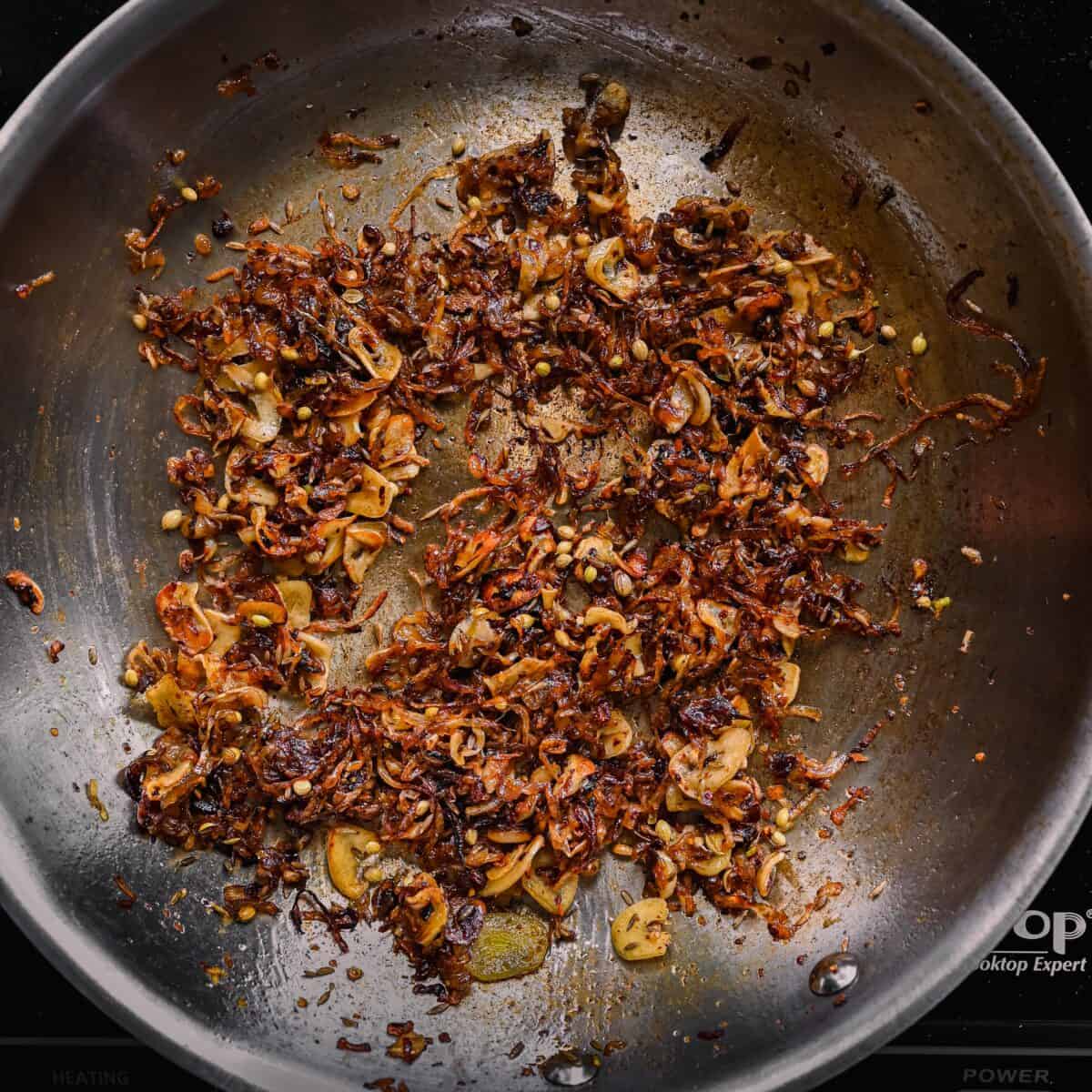 caramelized shallots and garlic with spices in a skillet