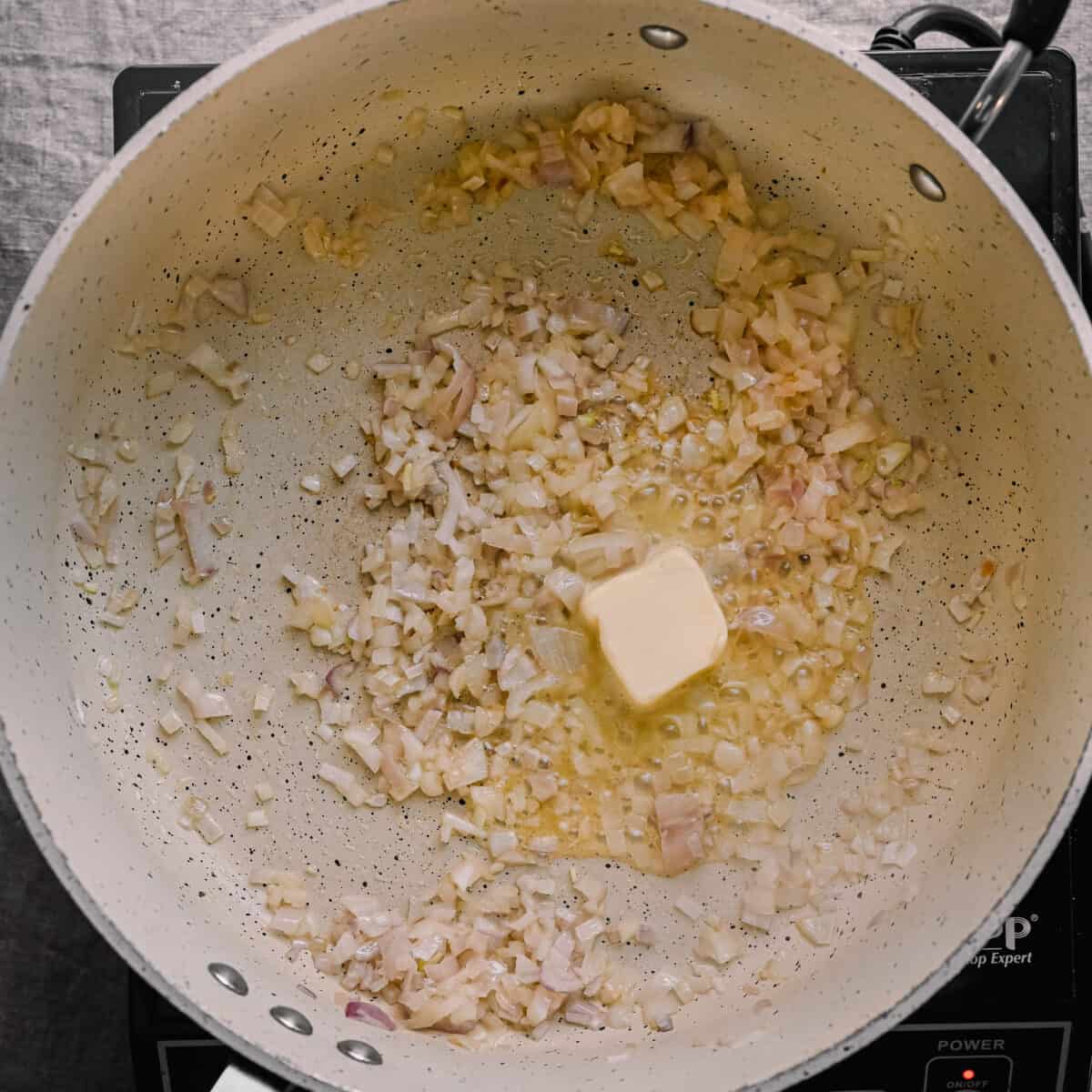 pat of vegan butter in skillet with shallots