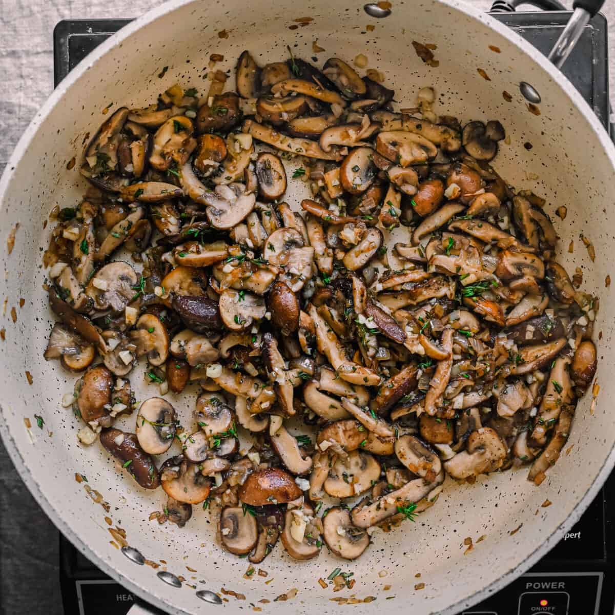 mushrooms cooked down with garlic and herbs in skillet