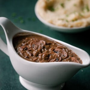 vegan gravy in a boat with mashed potatoes in the background