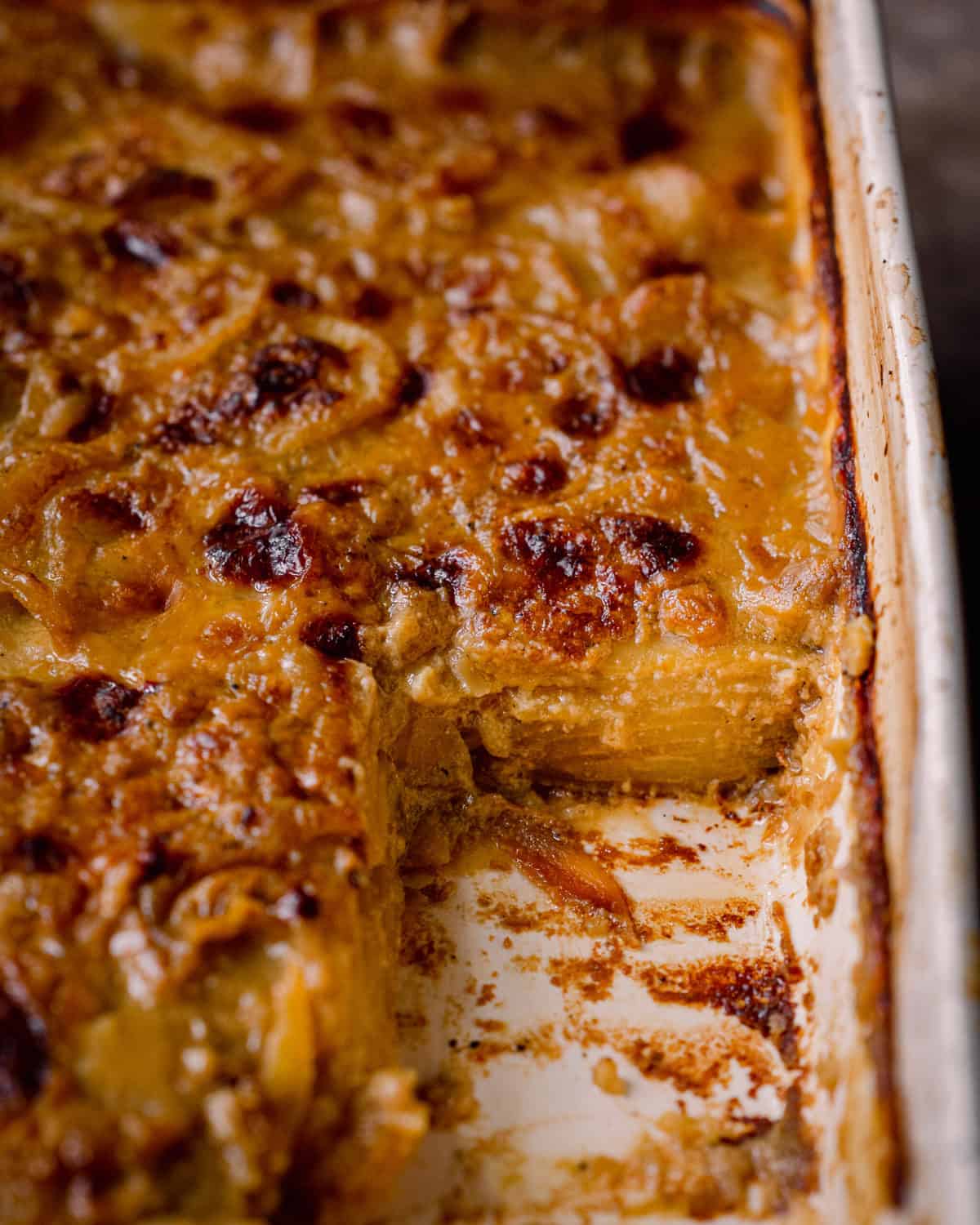 closeup shot of cheesy vegan scalloped potatoes in casserole pan